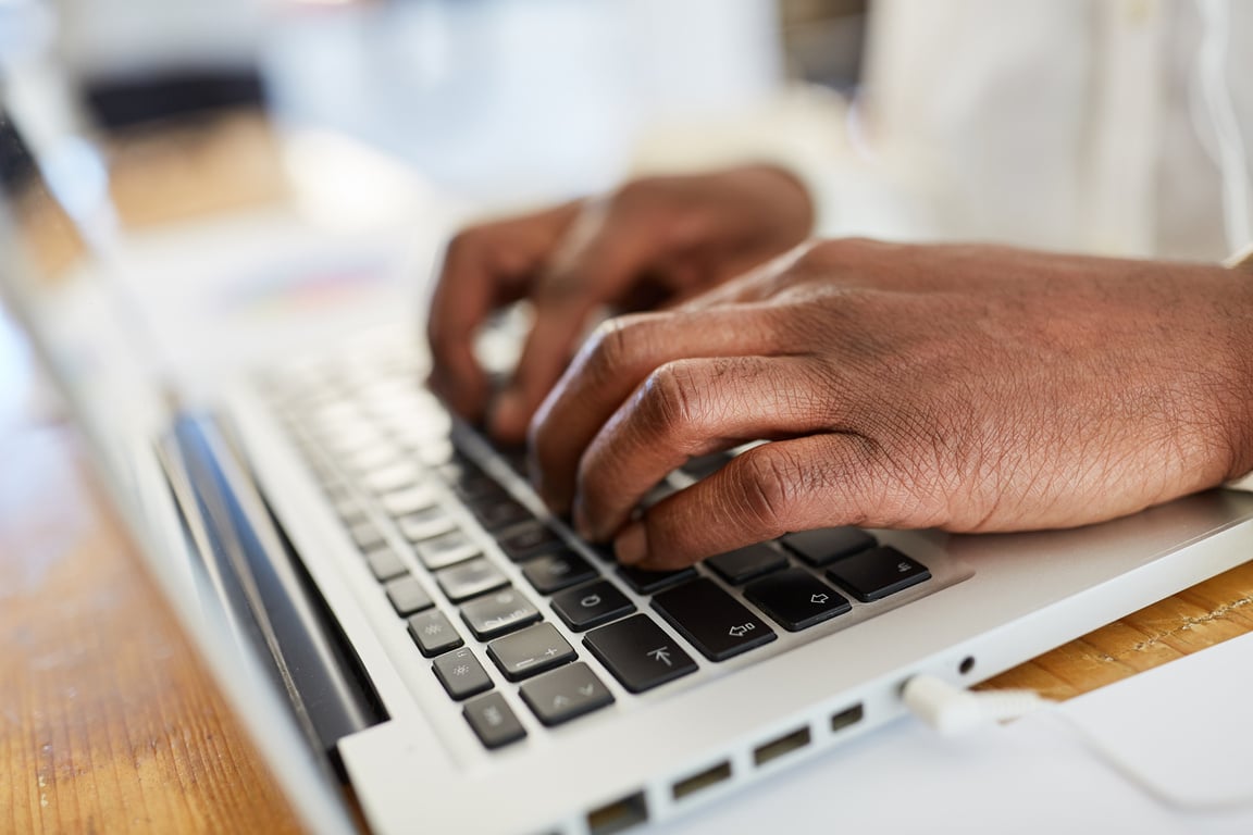 Hands of African Business Man Writing on Computer