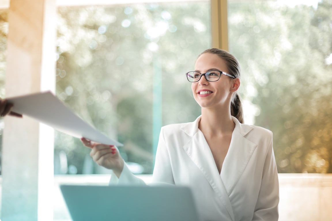 Positive businesswoman doing paperwork in office